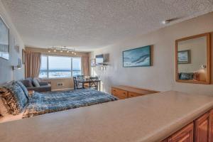 a hotel room with a bed and a living room at Top Floor Condo With Amazing Views Pool and Sauna in Lincoln City