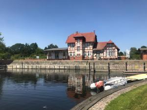 a large house with a boat in the water at Glampingpod in Loitz