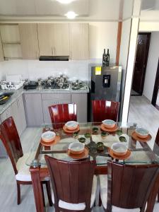 a kitchen with a table and chairs and a kitchen with a stove at Apto 205 Apartahotel Los Pinos in Sáchica