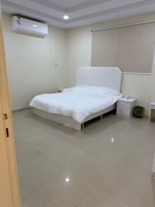 a bedroom with a bed in a room with white floors at شقة خالد المفروشة in Quai