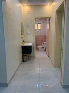 a hallway of a bathroom with a toilet and a sink at شقة خالد المفروشة in Quai