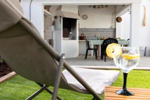 a glass of wine sitting on a chair in a yard at Retiro das Buganvílias in Sesimbra