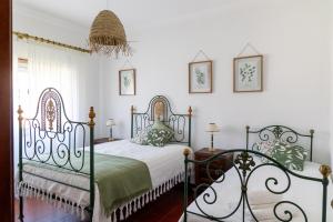 a bedroom with two metal beds in a room at Retiro das Buganvílias in Sesimbra