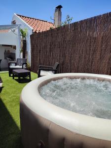 a large hot tub in a yard next to a fence at Retiro das Buganvílias in Sesimbra
