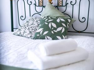 a white bed with pillows and a black and white headboard at Retiro das Buganvílias in Sesimbra +18 photos