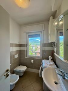 a bathroom with a sink and a toilet and a window at 1Dest - The Roman Spot in Riva del Garda