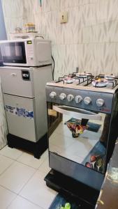 une cuisine avec une cuisinière et un micro-ondes dans l'établissement Mini Studio tres chic, à Dakar