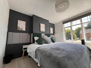 a bedroom with a bed with a black accent wall at Abbey Wood Residence in Abbey Wood