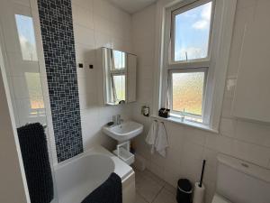 a white bathroom with a sink and a bath tub at Abbey Wood Residence in Abbey Wood +41 photos