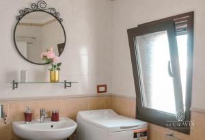 a bathroom with a sink and a toilet and a mirror at B&B sa' GRAVIN in Castellaneta +27 photos