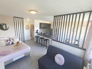 un soggiorno con divano e cucina di LeRelaisdOdile - Idéal PRO & Couple - Studio Cosy - Proche Metro - Parking Gratuit - Mons-en-Barœul - - WIFI HD - Smart TV - Entrée Autonome a Mons-en-Baroeul