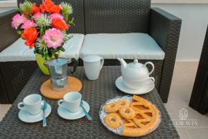a table with a tea pot and pretzels and flowers at B&B sa' GRAVIN in Castellaneta