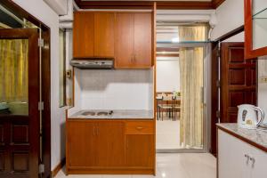 a kitchen with wooden cabinets and a counter top at White Base in Bangkok