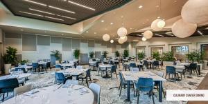 Lakeview property-Resort Amenities-3 Beds 2 Baths في Lorraine: غرفة طعام مع طاولات بيضاء وكراسي زرقاء