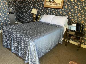 a bedroom with a bed with a blue and white comforter at Delux Inn in Big Spring