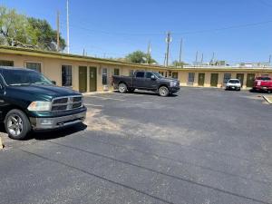 a parking lot with two trucks parked in front of a building at Delux Inn in Big Spring