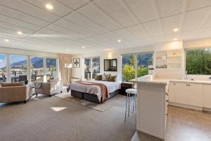 a bedroom with a bed and a kitchen and a living room at Queenstown House Bed & Breakfast and Apartments in Queenstown