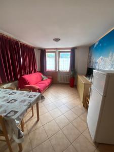 a living room with a red couch and a table at Casa Mara - Agriturismo Fantelli Luciano in Dimaro