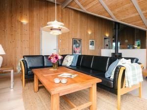 a living room with a black couch and a table at 5 person holiday home in Henne in Henne Strand