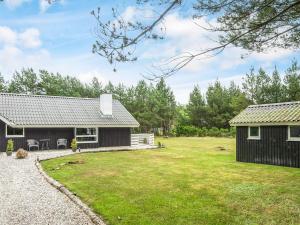 una casa con un patio y un edificio en Bright Cottage with Covered Terrace-By Traum, en Nørre Nebel