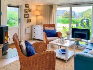 布洛克胡斯4 person holiday home in Blokhus-By Traum的带沙发、椅子和壁炉的客厅