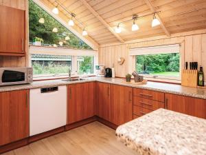 cocina grande con armarios de madera y microondas en 7 person holiday home in Oksbøl, en Oksbøl