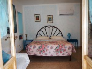 a bedroom with a bed with a floral bedspread at Appartamenti by the Hill in Fertilia