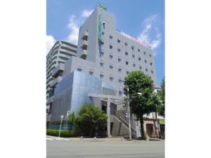 a tall white building on the corner of a street at Minami Fukuoka Green Hotel - Vacation STAY 34040v in Fukuoka +13 photos