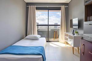 a bedroom with a bed and a large window at Today Perdizes in Sao Paulo