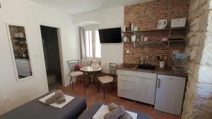 a kitchen with a counter and a table in a room at Roko's in Hvar