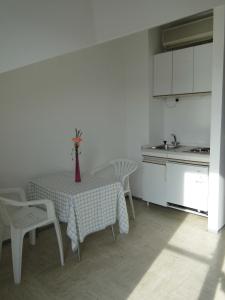 eine Küche mit einem Tisch und einer Blumenvase darauf in der Unterkunft Apartments Majic in Trogir