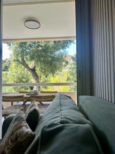 a living room with a couch and a large window at L'appartement Vert, Piscine, 750m de la Plage in Cavalaire-sur-Mer +37 photos