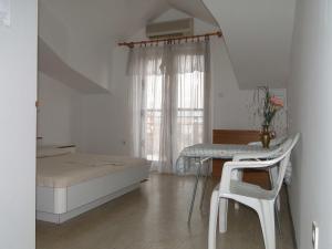 1 dormitorio con cama, mesa y ventana en Apartments Majic, en Trogir