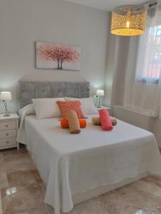 a bedroom with a white bed with two pillows on it at APARTAMENTO SOL - 2 apartamentos céntricos juntos cerca de la playa, ideales para grupos grandes in Águilas