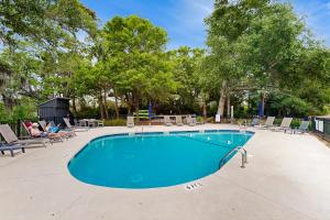 una piscina con gente sentada en sillas alrededor en Bay Pointe 2119, en Seabrook Island