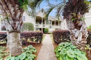 Un jardín con dos palmeras y algunas lechugas. en Bay Pointe 2119, en Seabrook Island