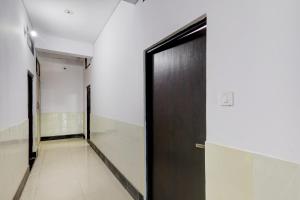 HasanganjHotel O SRV Palace的走廊上的黑色门,走廊上设有走廊