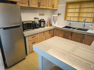 a kitchen with a stainless steel refrigerator and wooden cabinets at Banglo Inap Asiah in Kuala Terengganu +4 photos