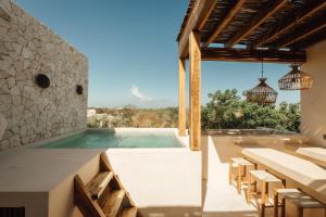 a pool in a house with tables and chairs at Satori Tulum in Tulum