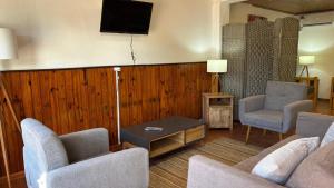 a living room with two chairs and a tv on the wall at Casa Chuy Barcelona in Chuy