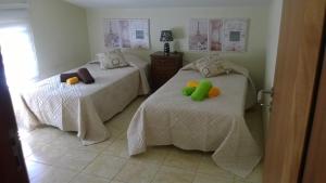 a bedroom with two beds with pillows on them at Apartamento Teixeira 2 in Arco da Calheta