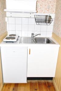 una cucina con armadi bianchi e lavandino di Åsens By a Haurida