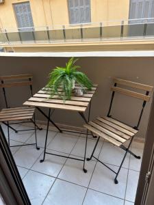a table and two chairs and a plant on a balcony at Sofia's Home in Chania Town