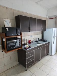 a kitchen with a sink and a microwave and a refrigerator at Departamento equipado, centrico, cochera cubierta Sarmiento265apart D15 in San Fernando del Valle de Catamarca +10 photos
