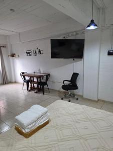 a room with a table and a tv and a chair at Departamento equipado, centrico, cochera cubierta Sarmiento265apart D15 in San Fernando del Valle de Catamarca