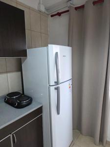 a white refrigerator in a kitchen next to a counter at Departamento equipado, centrico, cochera cubierta Sarmiento265apart D15 in San Fernando del Valle de Catamarca