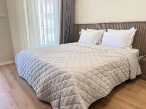 een slaapkamer met een groot bed met witte lakens bij Casa Magnolia in Vlorë +29 foto's