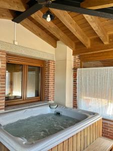 a large bath tub in a room with a window at Altillo del Aravalle in Umbrías