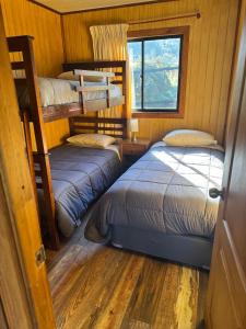 a bedroom with two bunk beds and a window at Cabańas Nordicas futrono in Futrono