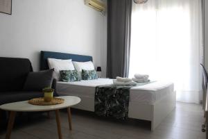 a bedroom with a bed and a couch and a table at stuDio57 11 in Alexandroupoli